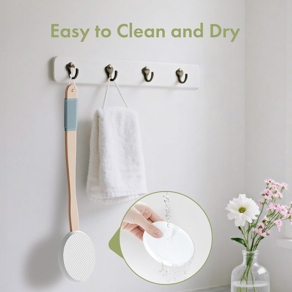 Wall-mounted hooks with a wooden spoon, towel, and small plant on a light gray wall.