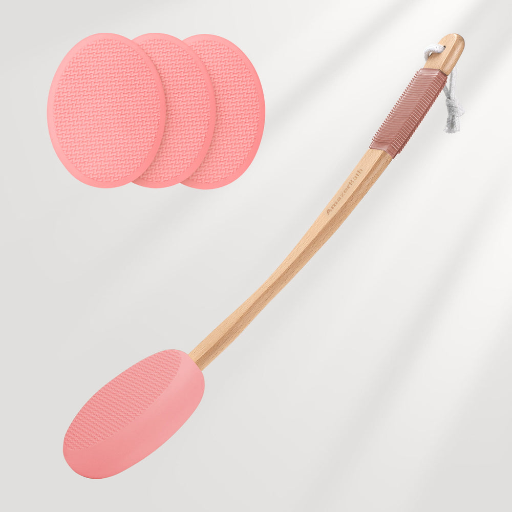 Pink silicone spatula with wooden handle and three additional silicone pads on a light gray background