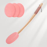 Pink silicone spatula with wooden handle and three additional silicone pads on a light gray background