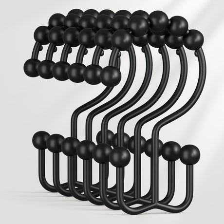 Set of black metal hooks with spherical ends on a white background
