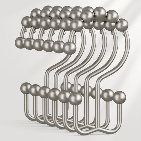Metallic hook rack with spherical ends on a light gray background