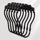 Set of black curtain hooks on a light gray background