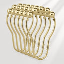 Set of gold safety pins on a light gray background