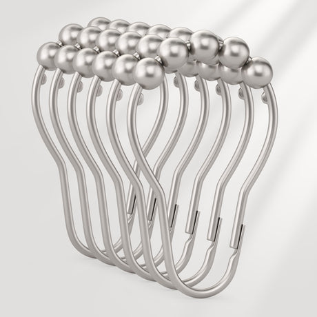 Metallic hair clip with pearl-like beads on a light gray background