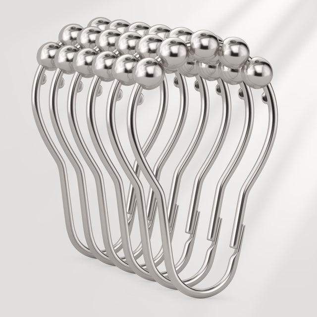 Set of silver curtain hooks on a white background