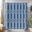 Shower curtain with geometric pattern in blue and white, hanging in a bathroom.