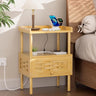 Bamboo nightstand with electronic devices on top next to a bed