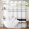 Striped shower curtain with a white bathtub and bathroom decor.