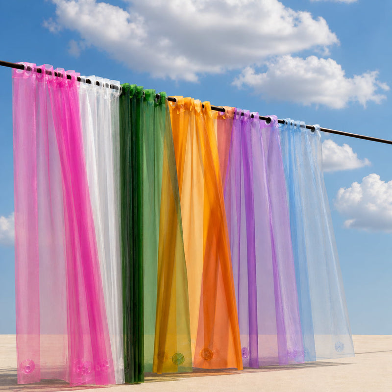 Colorful sheer curtains hanging against a blue sky with clouds