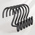 Set of black metal hooks with decorative elements on a white background