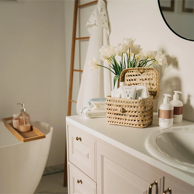 AmazerBath bathroom vanity with a woven storage basket, flowers, mirror, and countertop essentials