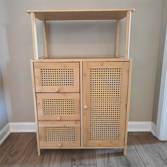 Wooden cabinet with rattan-style doors and drawers against a plain wall.