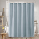 Blue shower curtain in a bathroom setting with bathtub and towel rack.
