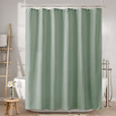 Green shower curtain in a bathroom setting with bathtub and towel rack.