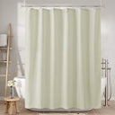 Beige shower curtain in a bathroom setting with bathtub and towel rack.
