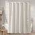 Beige shower curtain in a bathroom setting with a bathtub and decorative elements.