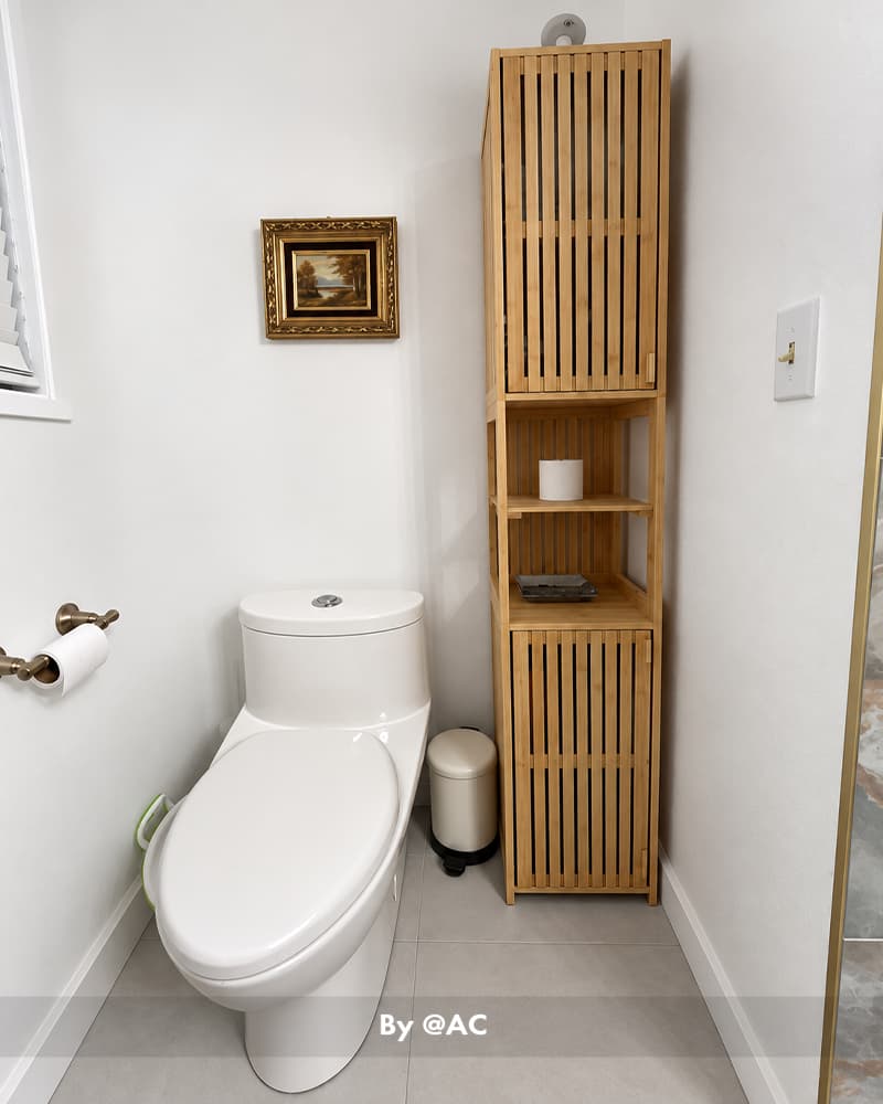 AmazerBath slim bamboo bathroom storage cabinet standing beside a white toilet with open shelves and a lower door.