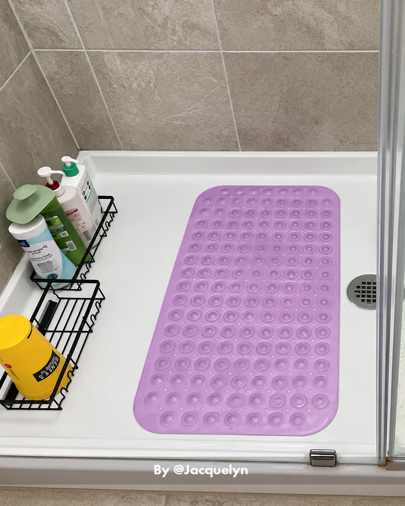 Customer bathroom photo showing a small bathtub mat placed beside or inside a tub, with the mat visible in the bath setting.