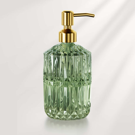Green glass soap dispenser with gold pump on a white background