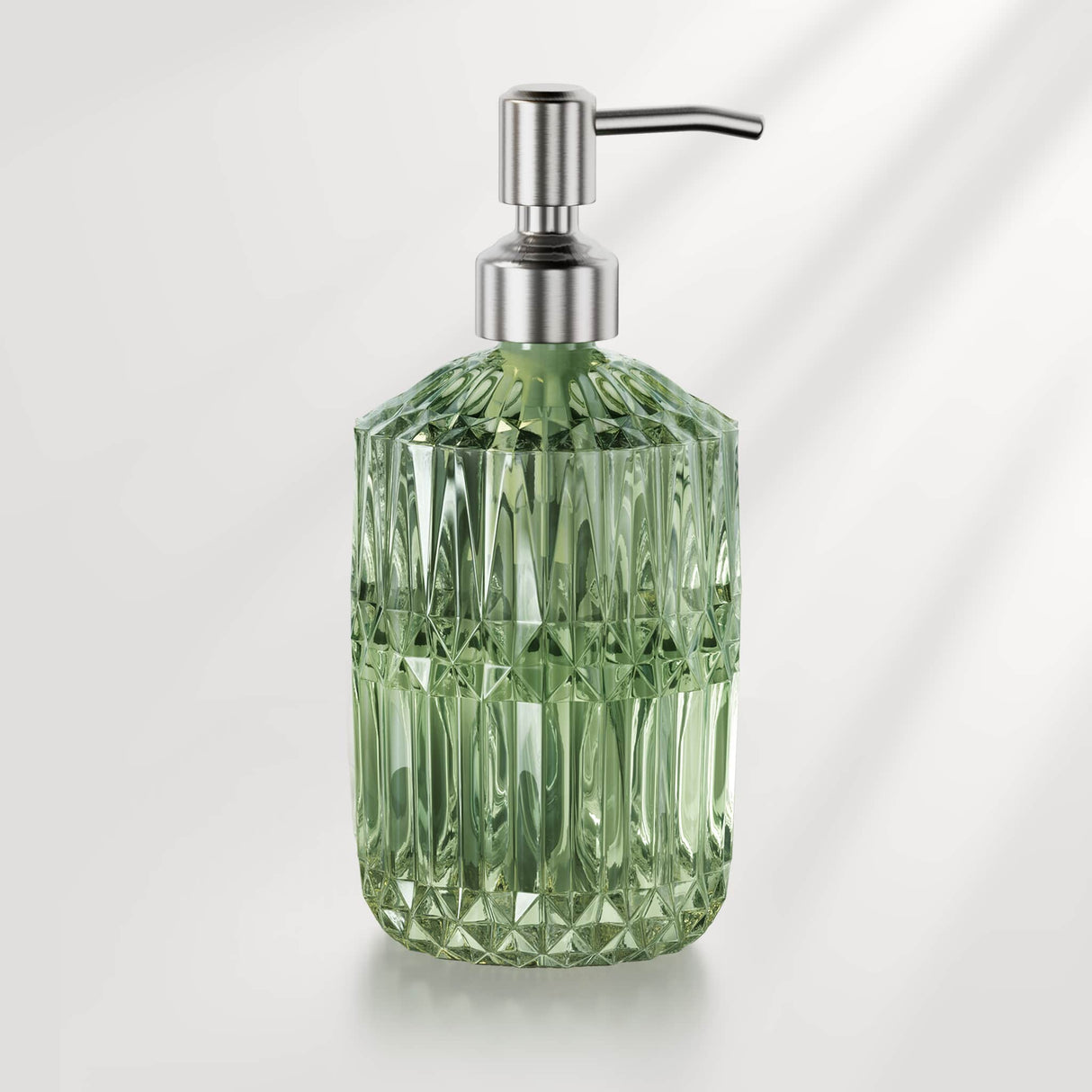 Green diamond-patterned soap dispenser with metallic pump on a light gray background
