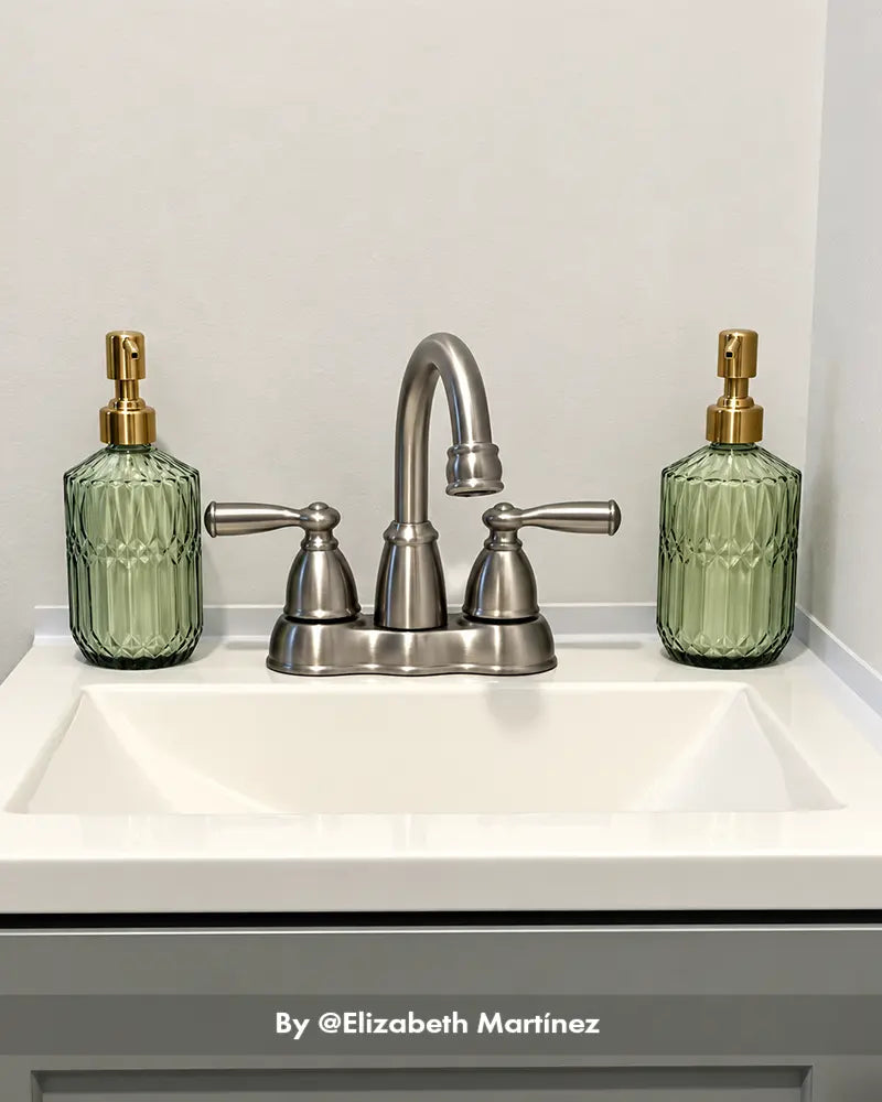 AmazerBath green ribbed glass soap dispenser pair with gold pumps displayed on both sides of a brushed nickel bathroom faucet.