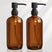Two brown bottles with black pumps on a white background