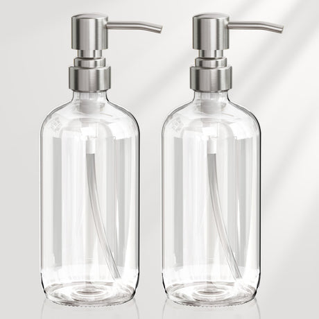 Two clear glass bottles with silver pump dispensers on a light gray background