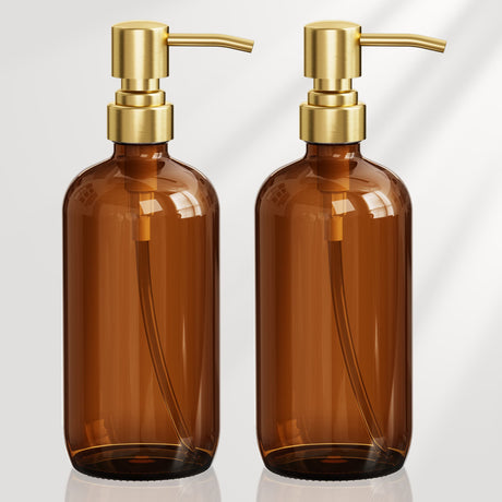 Two brown bottles with gold pumps on a white background