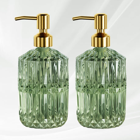 Two green glass soap dispensers with gold pumps on a white background