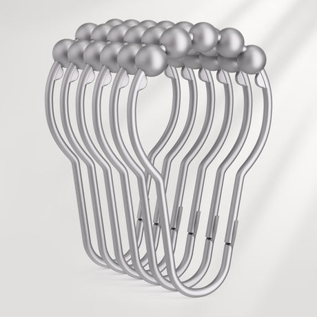 Set of silver shower curtain hooks on a light gray background