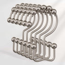 Set of metal hooks with spherical ends on a light gray background