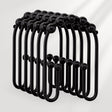 Black metal hooks arranged in a circular pattern on a white background