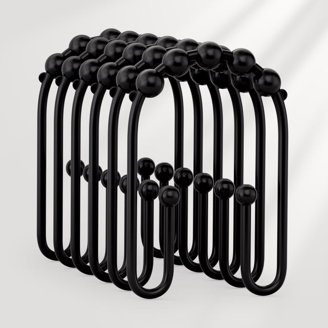 Black metal hooks arranged in a circular pattern on a white background