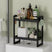 AmazerBath black bamboo two-tier toilet rack holding toiletries and tissue boxes.