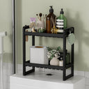 AmazerBath black bamboo two-tier toilet rack holding toiletries and tissue boxes.