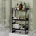 AmazerBath black bamboo three-tier toilet rack holding toiletries, towels and tissue boxes.