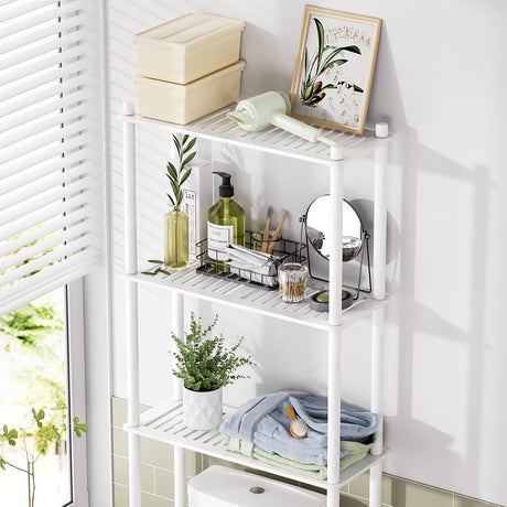 AmazerBath white bamboo over-the-toilet storage shelf organized with towels, toiletries, and decor.