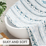 AmazerBath blue Boho Haven geometric shower curtain draped over a bathtub to show its silky, soft fabric.