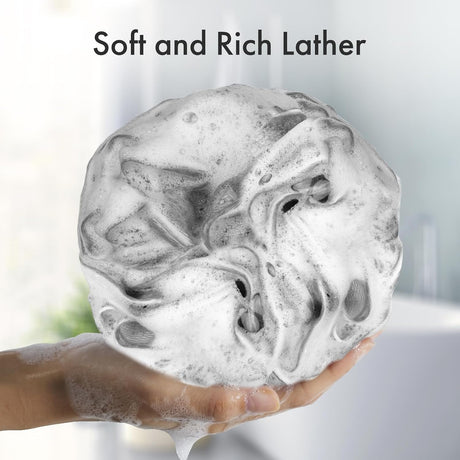 AmazerBath melon charcoal loofah sponge covered in soft, rich soap lather in a hand.