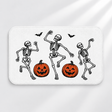 Linocut skeleton Halloween bath mat with dancing bones and pumpkins on a light gray background
