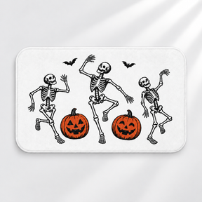 Linocut skeleton Halloween bath mat with dancing bones and pumpkins on a light gray background