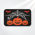 Spiderweb Halloween bath mat with jack-o'-lanterns and flying bats on a light gray background