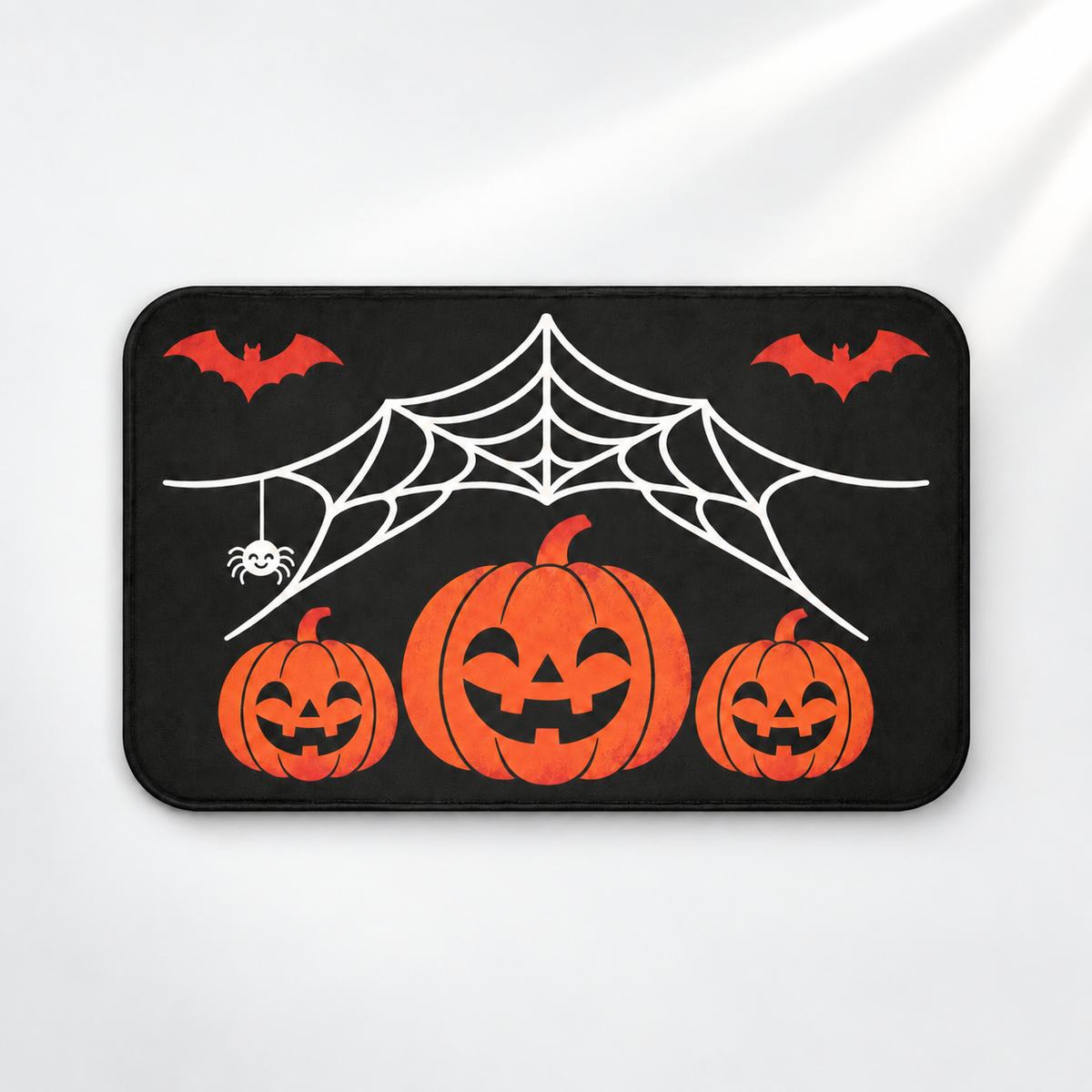 Spiderweb Halloween bath mat with jack-o'-lanterns and flying bats on a light gray background