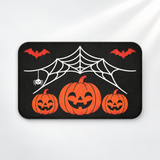 Spiderweb Halloween bath mat with jack-o'-lanterns and flying bats on a light gray background
