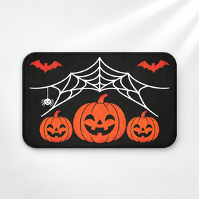 Spiderweb Halloween bath mat with jack-o'-lanterns and flying bats on a light gray background
