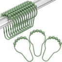 Green beaded shower curtain hooks on a white background