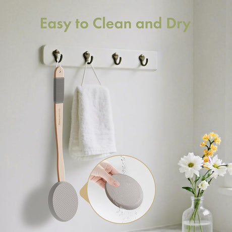 AmazerBath Grey back lotion applicator rinsed under water and hanging beside a towel to air-dry.