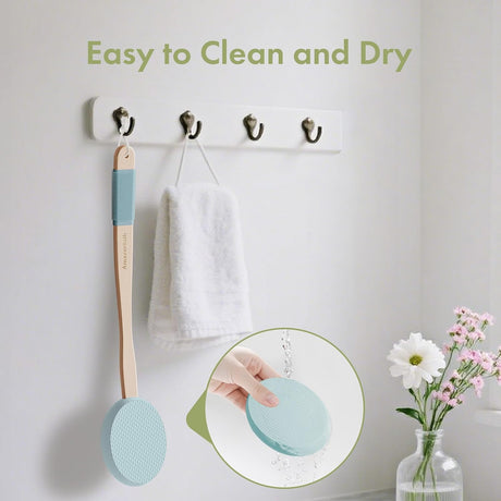 AmazerBath Sky Blue back lotion applicator rinsed under water and hanging beside a towel to air-dry.