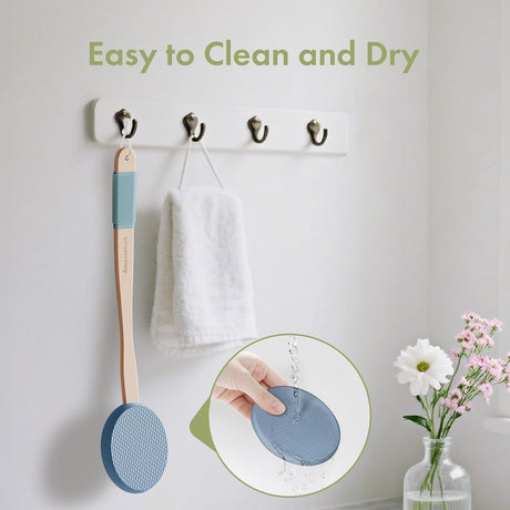 AmazerBath Slate Blue back lotion applicator rinsed under water and hanging beside a towel to air-dry.