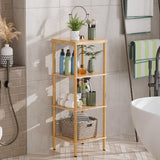 AmazerBath natural bamboo four-tier standing shelf holding bottles, towels, a basket, and plants beside a bathtub.